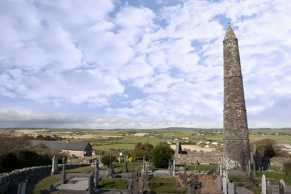 Irish Ancient round tower and celtic graveyard with cathedral — Stock Photo, Image