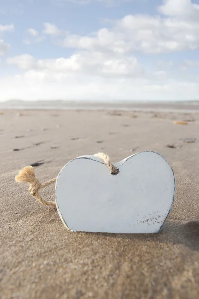 Alone wooden love heart in the sand — Stock Photo, Image