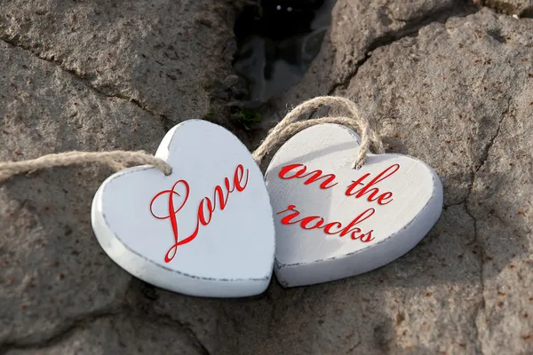 Amor en las rocas corazones de madera — Foto de Stock