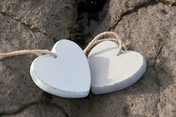Wooden love hearts on the sand bank — Stock Photo, Image