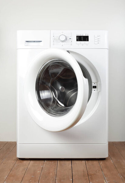 Major appliance - Front view open door washing machine on a white and wood background