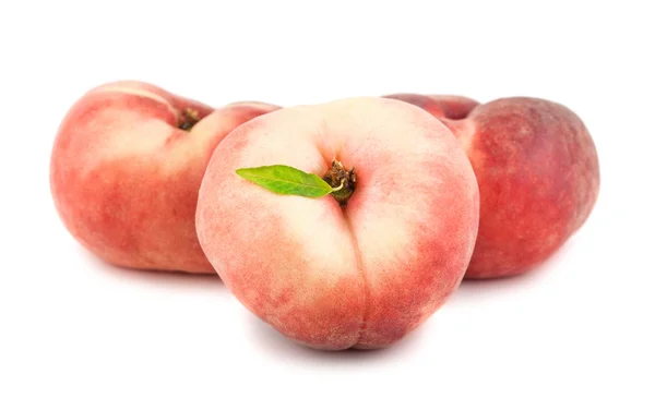 Три плоских персика — стоковое фото