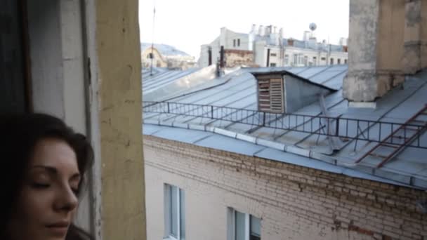 Hermosa mujer en un control deslizante de ventana — Vídeo de stock