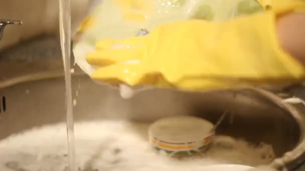 Женщина моет посуду — стоковое видео