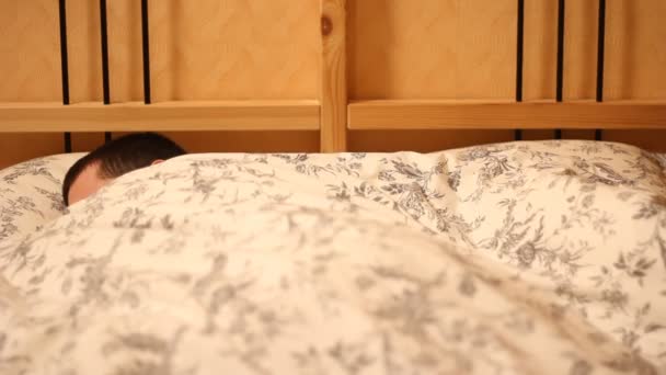Человек спит в своей постели — стоковое видео