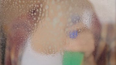 kadın pencereyi temizliyor