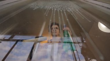 kadın pencereyi temizliyor