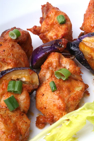 Pollo a la parrilla en un plato blanco con verduras en el fondo . —  Fotos de Stock