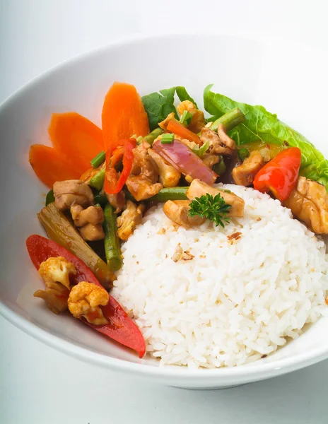 Chicken with rice and vegetables in background — Stock Photo, Image