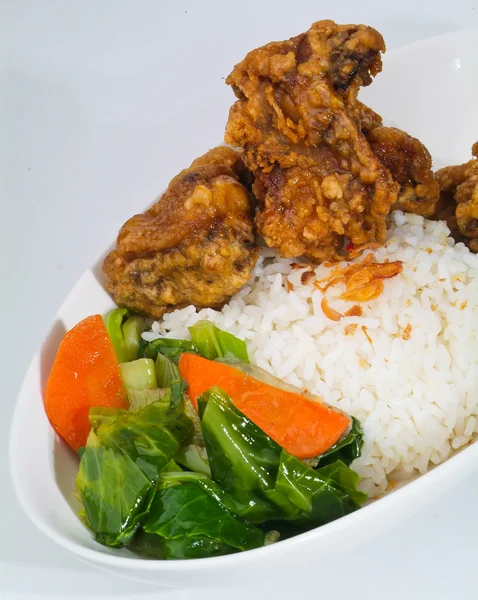 Chicken with rice and vegetables in background — Stock Photo, Image