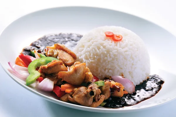 Chicken with rice and vegetables in background — Stock Photo, Image