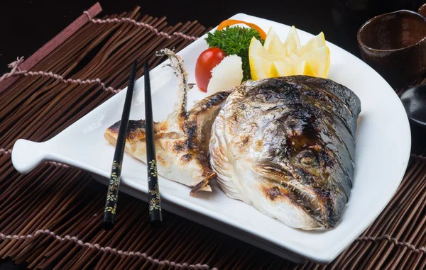 Страви японської кухні. голови смаженої риби на задньому плані — стокове фото