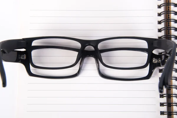 Anteojos. gafas de ojo con libro en el fondo — Foto de Stock