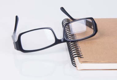 gözlükleri. Gözlükleri ile arka planda kitap