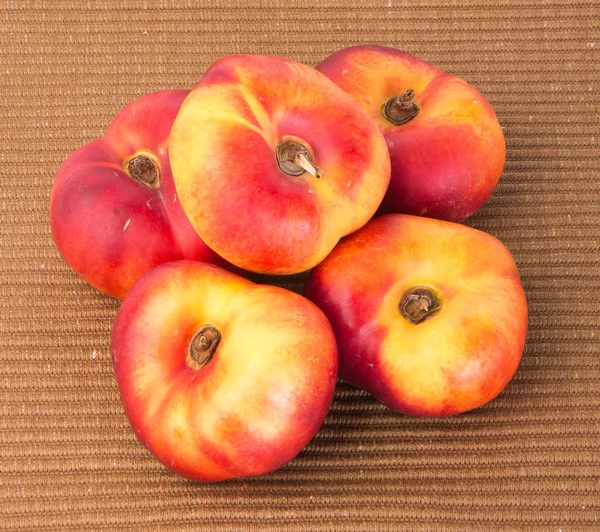 flat peaches (donut peaches) on a background