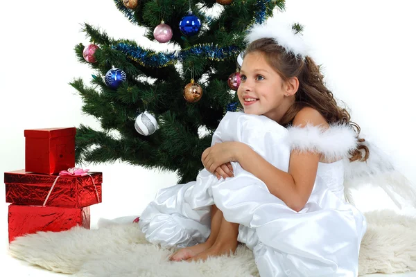 Beyaz bir arka plan üzerinde izole bir Noel ağacı yakınındaki küçük güzel kız — Stok fotoğraf