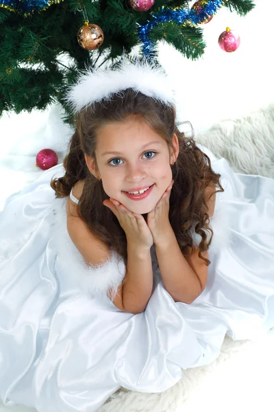 Niña hermosa cerca de un árbol de Navidad aislado sobre un fondo blanco —  Fotos de Stock