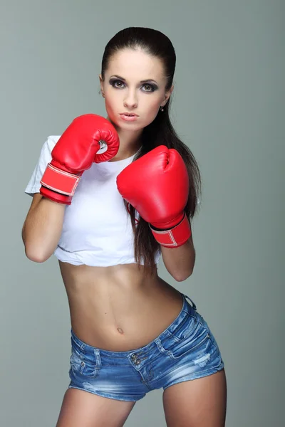 Bela menina boxe sexual, fitness, em um fundo cinza — Fotografia de Stock