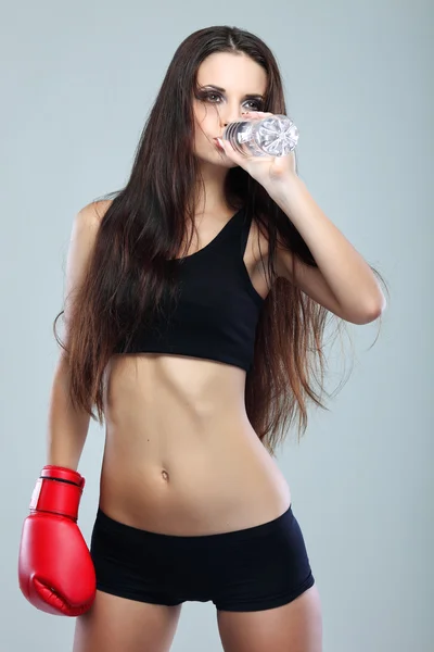 Hermosa chica de boxeo sexual, fitness, sobre un fondo gris — Foto de Stock