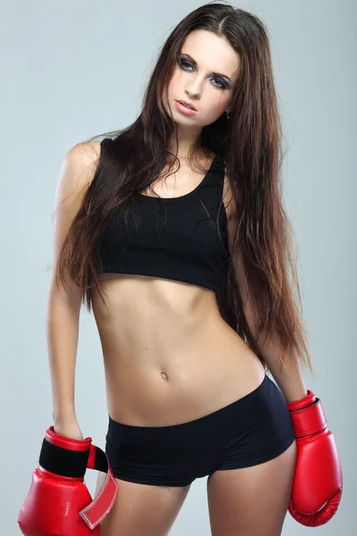 Bela menina boxe sexual, fitness, em um fundo cinza — Fotografia de Stock