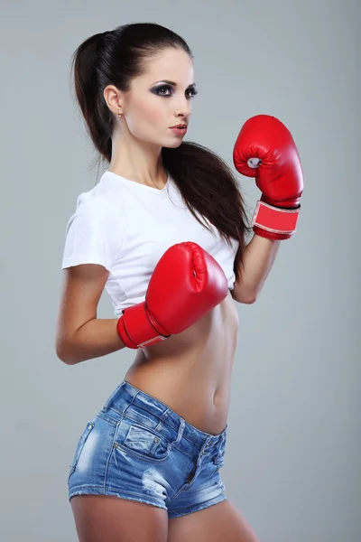 Bela menina boxe sexual, fitness, em um fundo cinza — Fotografia de Stock