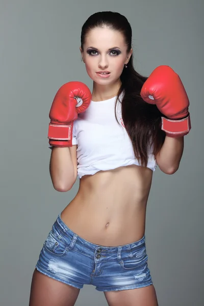 Hermosa chica de boxeo sexual, fitness, sobre un fondo gris — Foto de Stock