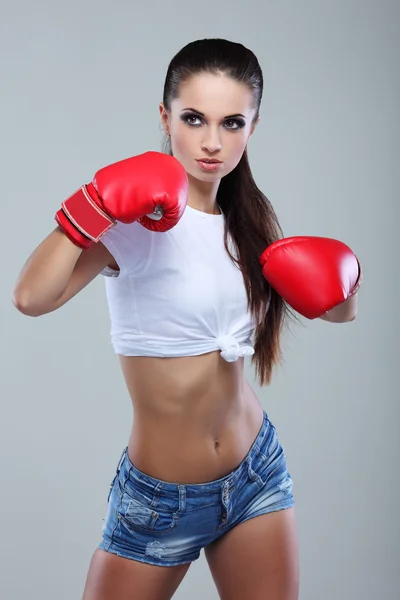 Bela menina boxe sexual, fitness, em um fundo cinza — Fotografia de Stock