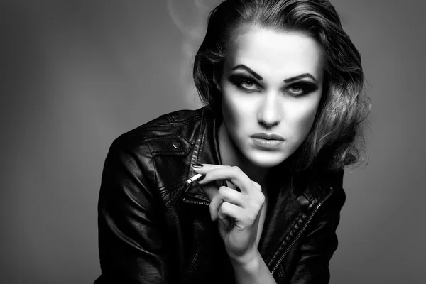 Een portret van mooi seksuele roodharige meisje is in een zwart lederen jas, roken van een sigaret — Stockfoto
