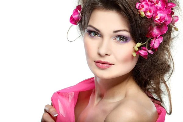 Porträt der schönen sexuellen Brünette mit rosa Orchideen im Haar. Emotionen, Kosmetik — Stockfoto