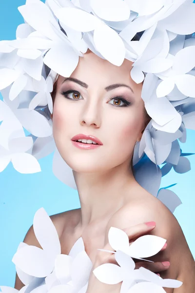 Ragazza meravigliosa in un cappello da farfalle bianche di carta. Su uno sfondo blu. Bellezza viso — Foto Stock