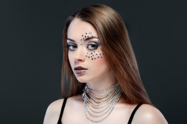 Yüzünde koyu gri arka plan üzerinde strasses ile cinsel güzel kız portresi