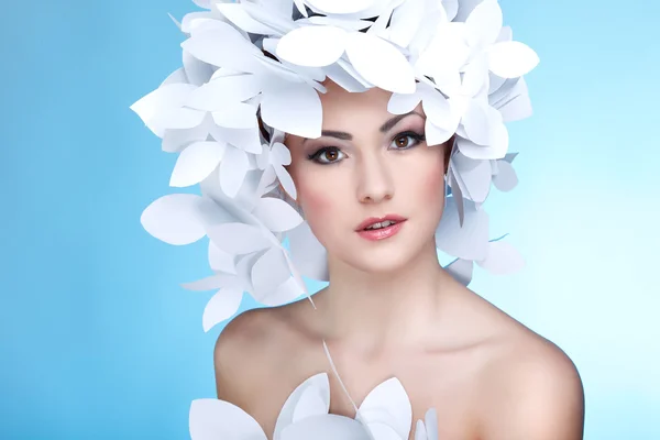 Maravillosa chica con sombrero de mariposas blancas de papel. Sobre un fondo azul. Cara de belleza — Foto de Stock