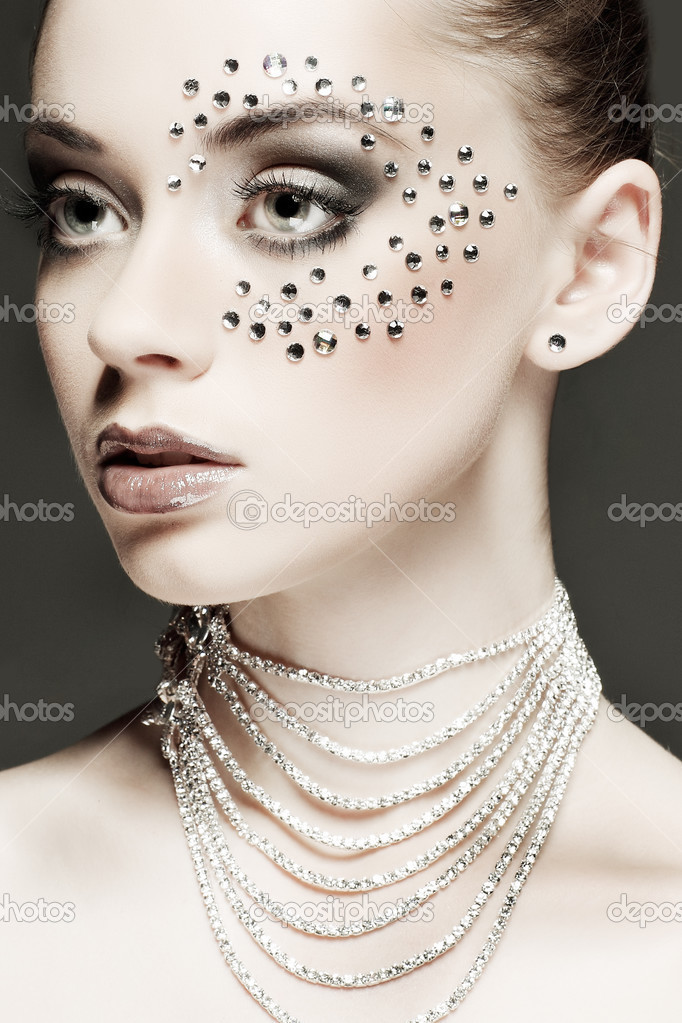 Portrait of sexual beautiful girl with strasses on face, on a dark-grey background