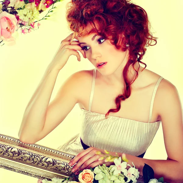 Beautiful redheaded girl with the bouquet of tulips, which stands in a gold frame, flowered, isolated on a white background — Stock Photo, Image