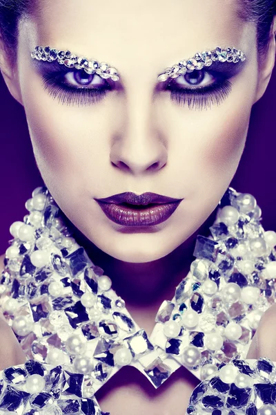 Portrait de belle fille sexuelle avec des strass sur le visage, sur un fond violet — Photo