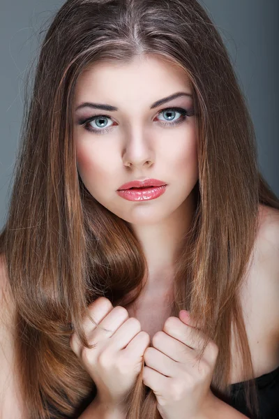 Retrato de cerca de una joven sexy con hermosos ojos azules sobre fondo gris — Foto de Stock