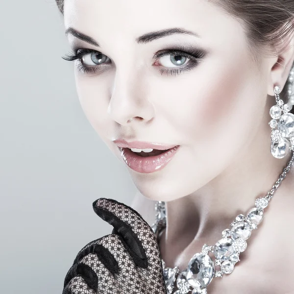 Ein Porträt eines eleganten Mädchens liegt im Trend. Hochzeitsschmuck. auf grauem Hintergrund — Stockfoto