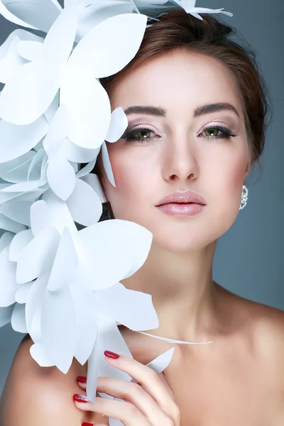 Ragazza meravigliosa in un cappello da farfalle bianche di carta. Su uno sfondo blu. Bellezza viso — Foto Stock