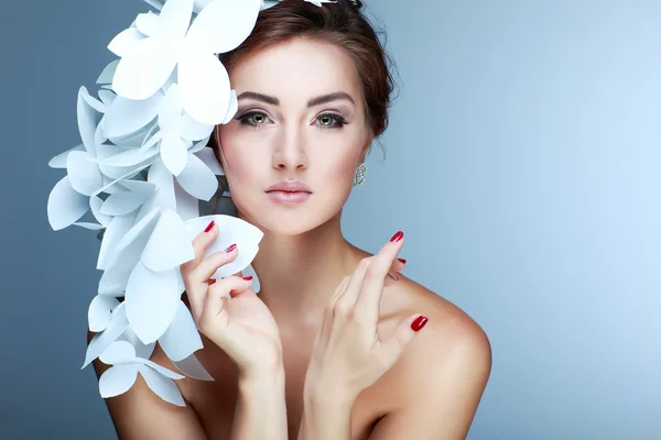 Ragazza meravigliosa in un cappello da farfalle bianche di carta. Su uno sfondo blu. Bellezza viso — Foto Stock