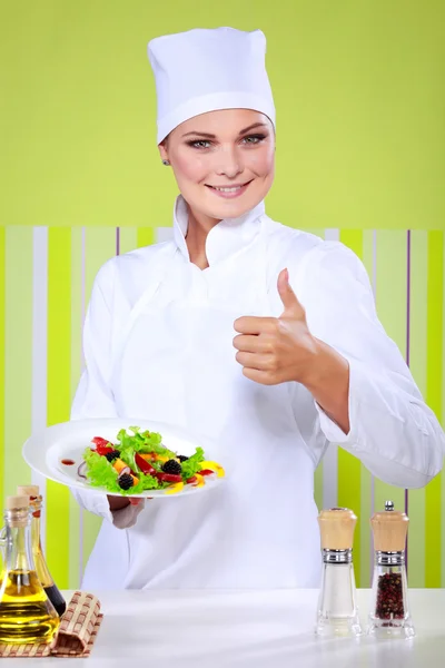 Όμορφη νεαρή σεφ γυναίκα προετοιμασία και διακόσμηση νόστιμο φαγητό στην κουζίνα — Φωτογραφία Αρχείου