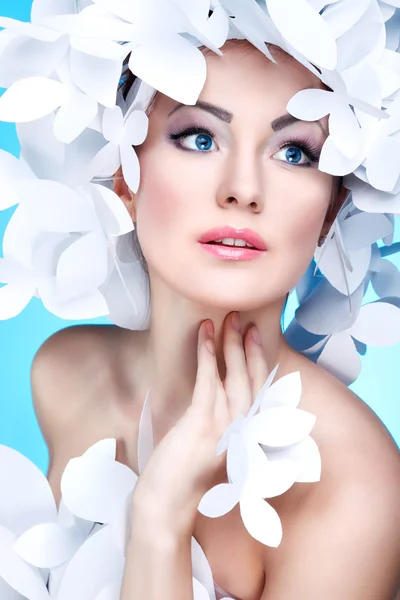Underbar tjej i en hatt från papper vita fjärilar. på en blå bakgrund. skönhet ansikte — Stockfoto
