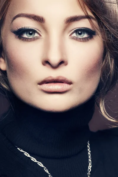 Retrato de jovem mulher elegante em um jumper preto em um fundo marrom — Fotografia de Stock