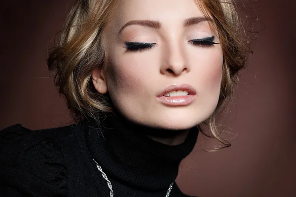 Portrait of elegant young woman in a black jumper on a brown background — Stock Photo, Image