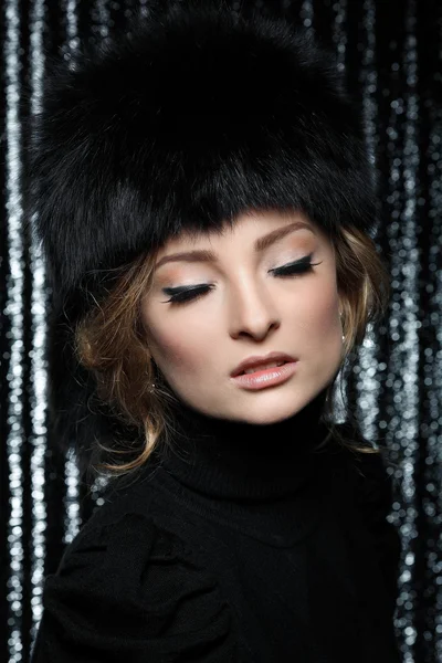 Retrato de jovem mulher elegante em um jumper preto em um fundo marrom — Fotografia de Stock