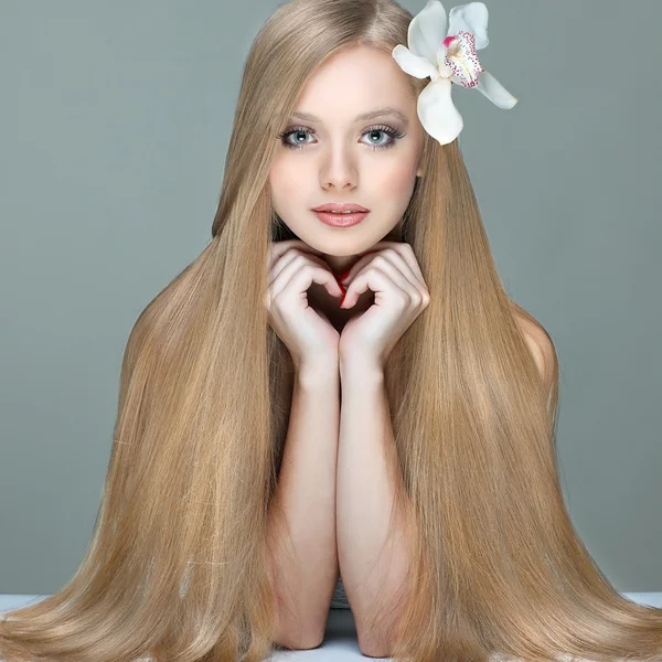 Portrait de belle fille aux cheveux longs avec une orchidée dans une coiffure — Photo