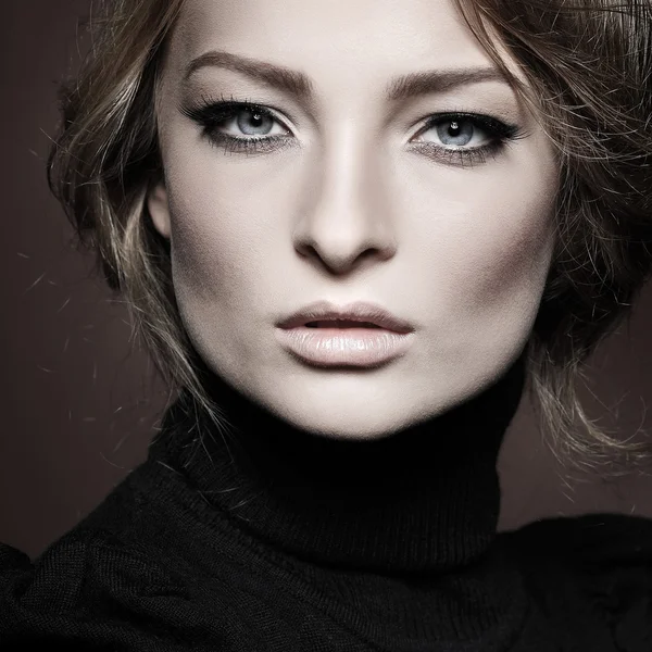 Portrait de jeune femme élégante en pull noir sur fond marron — Photo