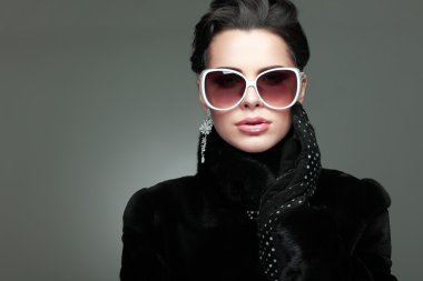 Kürk giymiş güzel bir kızın fotoğrafı var.