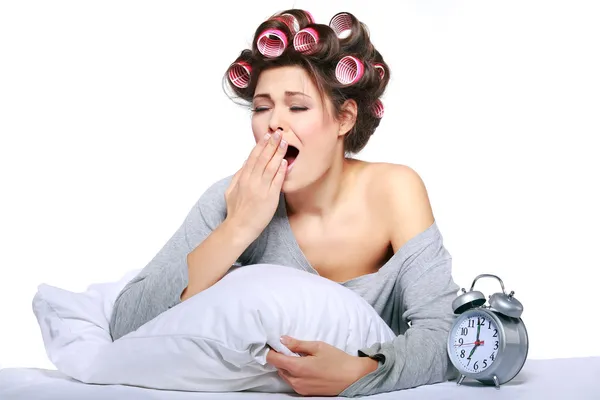 Happy positive young woman waking up and switching off the alarm clock — Stock Photo, Image