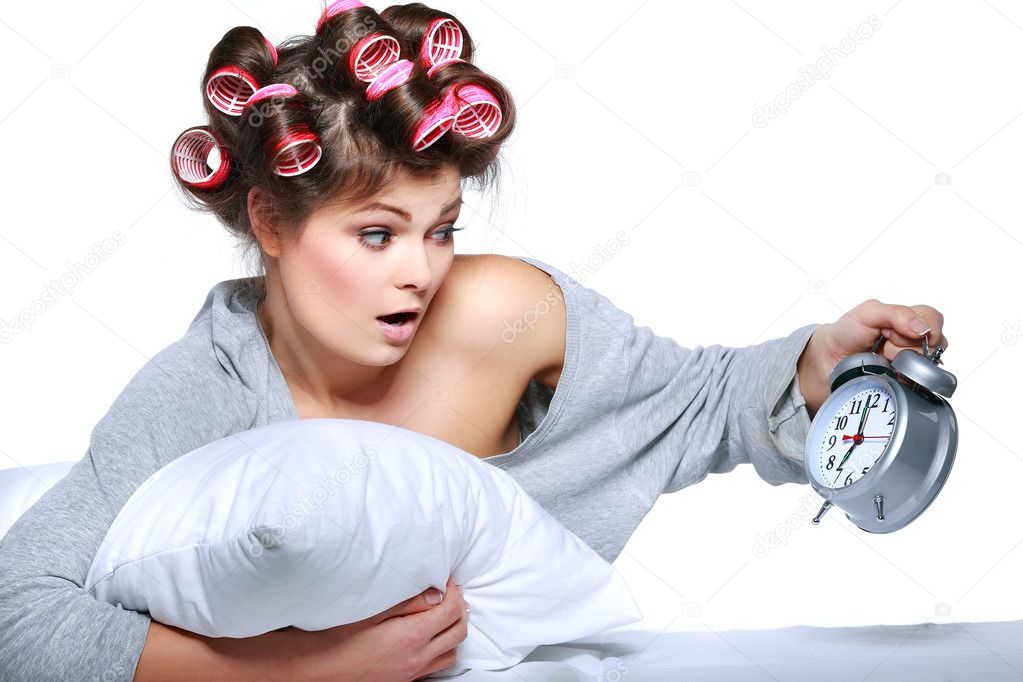 happy positive young woman waking up and switching off the alarm clock