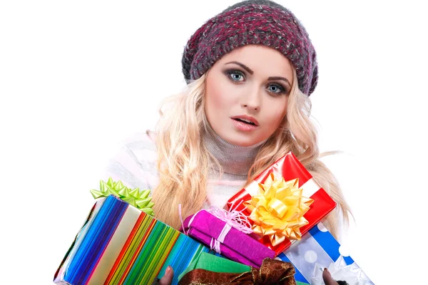 Une photo de belle fille est dans des vêtements d'hiver avec des boîtes-cadeaux varicolores, isolé — Photo